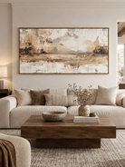 Large panoramic abstract waterscape wall art displayed above a sofa in a warm modern organic living room