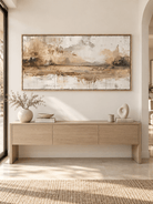 Large horizontal earth tone abstract landscape painting displayed above a long console in a contemporary entryway