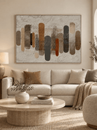 Large earth-tone textured geometric wall art displayed above a sofa in a modern organic living room