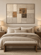 Beige and brown architectural abstract wall art displayed above a bed in a minimalist bedroom