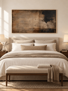 Moody earth tone abstract painting displayed above a bed in a warm neutral modern bedroom