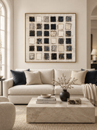 Large black and white geometric abstract painting displayed above a cream sofa in a contemporary living room