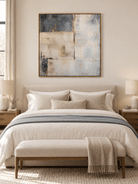Neutral textured color block painting in slate blue and ivory displayed above a bed in a modern bedroom