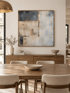 Hand-painted blue gray and beige geometric wall art displayed above a sideboard in an open-plan dining room