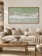 Large sage green ocean wave painting displayed above a cream sofa in a modern organic coastal living room