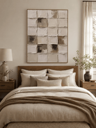 Cream and taupe wabi-sabi textured abstract painting displayed in a warm minimalist bedroom