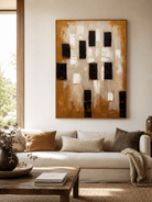 Large earth tone geometric wall art displayed above a beige sofa in an organic modern living room