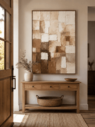 Vertical beige and brown wabi-sabi wall art displayed above an entryway console in a neutral modern interior
