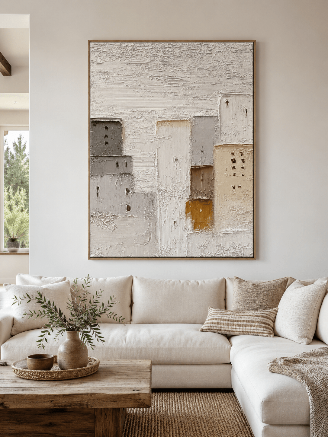 Large neutral textured architectural wall art displayed above a beige sofa in an organic modern living room