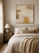 Cream and beige textured abstract painting displayed above the bed in a warm minimalist bedroom