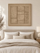 Monochrome sand beige relief painting displayed above the bed in a warm minimalist bedroom