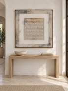 Square beige and gray textured wall art displayed above an entryway console in a Japandi interior