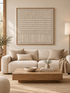 Large beige textured geometric wall art displayed above a cream sofa in an organic modern living room