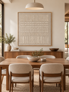 Large neutral geometric relief wall art displayed in an organic modern open dining room with natural wood furniture