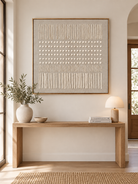 Square beige wabi-sabi textured wall art displayed above an entryway console in a Japandi-inspired interior