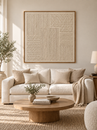 Large ivory textured geometric wall art displayed above a beige sofa in an organic modern living room