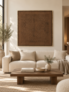 Large dark brown textured wall art displayed above a cream sofa in an organic modern living room