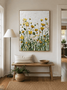 Vertical yellow wildflower wall art displayed above a console table in a welcoming entryway