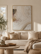 Neutral textured abstract wall art displayed above a beige sofa in an organic modern living room