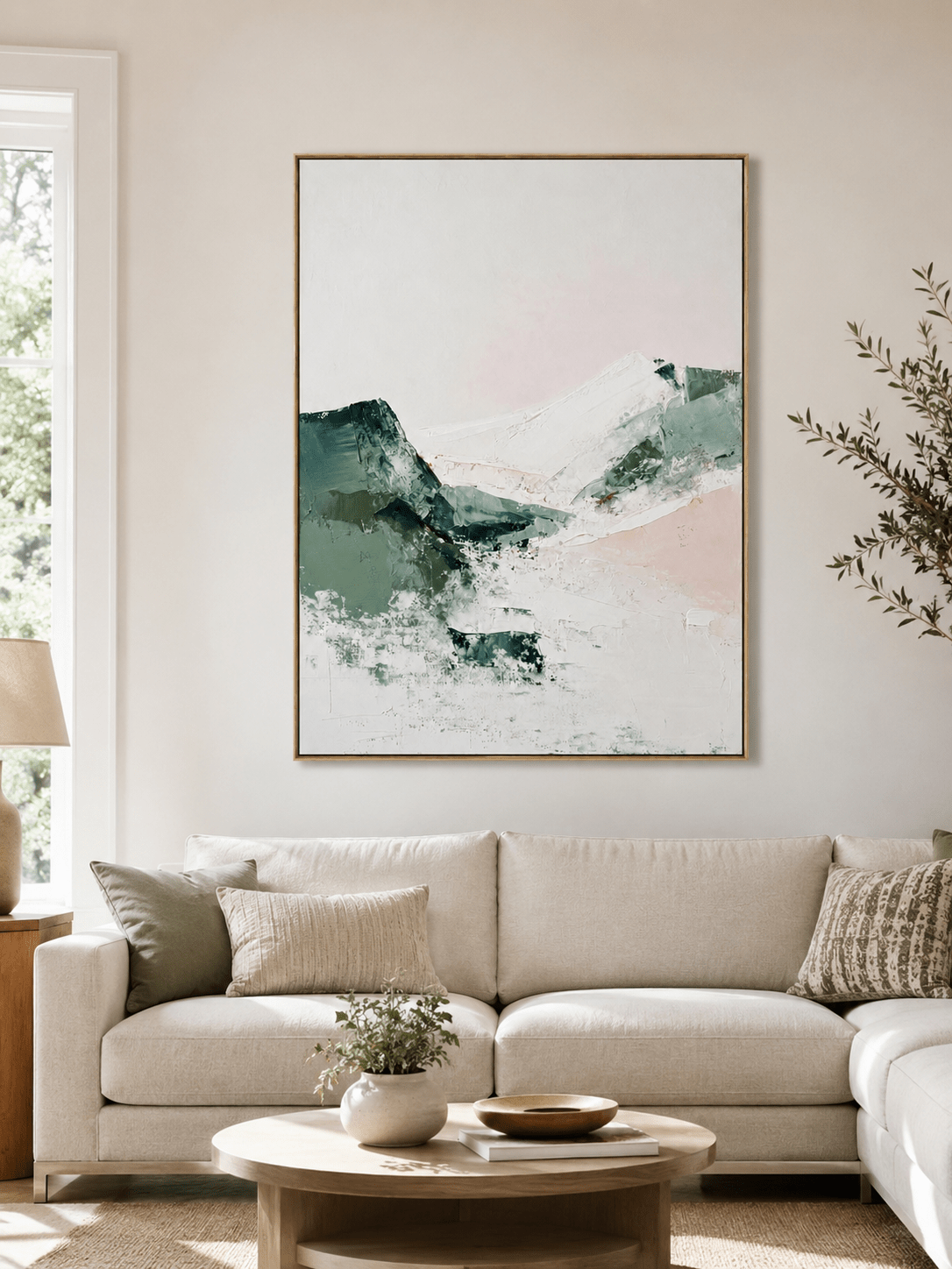 Sage green abstract mountain painting above a neutral sofa in an organic modern living room