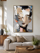 Neutral abstract face painting above a cream sofa in a contemporary living room