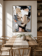 Neutral abstract portrait painting displayed in a modern open-plan dining room