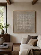 Neutral geometric grid wall art above a cream sofa in a wabi-sabi living room