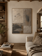 Neutral textured abstract painting above a cream sofa in an organic modern living room