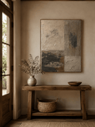 Neutral architectural wall art above an entryway console in a minimalist Japandi foyer