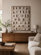 Neutral 3D pebble wall art above a cream sofa in an organic modern living room
