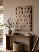 3D textured neutral wall art above an entryway console in a minimalist Japandi foyer