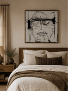 Expressionist face wall art displayed above a bed in a modern monochrome bedroom