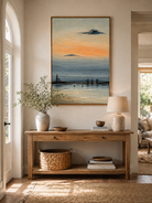 Textured coastal harbor painting displayed above a wood console in a modern neutral entryway