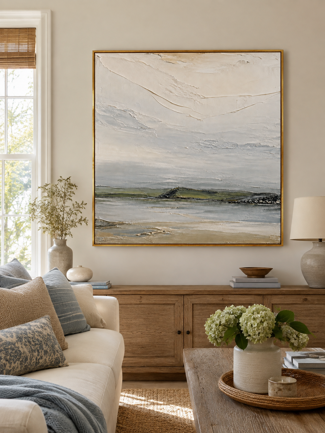Neutral textured coastal landscape painting by Evelyn Li displayed above a sofa in an organic modern living room
