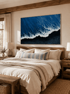 Deep blue ocean wave wall art displayed above the bed in a contemporary neutral bedroom