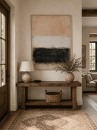 Wabi-Sabi beige and black abstract painting displayed above a wood console in a neutral entryway