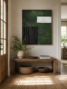 Vertical green and black abstract painting displayed above a wood console in an organic modern entryway