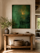 Vertical emerald green abstract painting displayed above a wood console in an organic modern entryway
