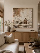 Neutral pottery still life painting displayed above a beige sofa in an organic modern living room