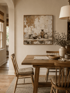 Hand-painted pottery still life wall art displayed in a dining room with natural wood furniture