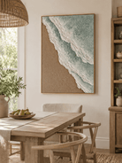 Hand-painted green and beige coastal wall art displayed in a dining room with natural wood furniture
