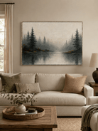 Misty forest landscape painting displayed above a neutral sofa in an organic modern living room