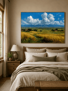 Golden countryside wall art with blue sky displayed above the bed in a bright neutral bedroom