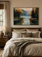 Golden autumn lake landscape displayed above the bed in a warm neutral bedroom