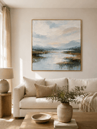 Large blue textured landscape wall art displayed above a beige sofa in an organic modern living room