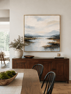 Large textured blue landscape wall art displayed in a contemporary open dining room with natural wood furniture