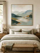 Textured green and blue mountain landscape painting displayed above the bed in a warm neutral bedroom