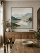 Large sage green textured landscape wall art displayed in a modern open dining room with natural wood furniture