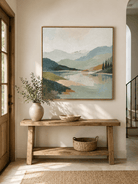 Sage green mountain lake wall art displayed above an entryway console in a contemporary neutral home