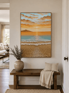 Coastal sunrise wall art above an entryway console in a bright organic modern foyer